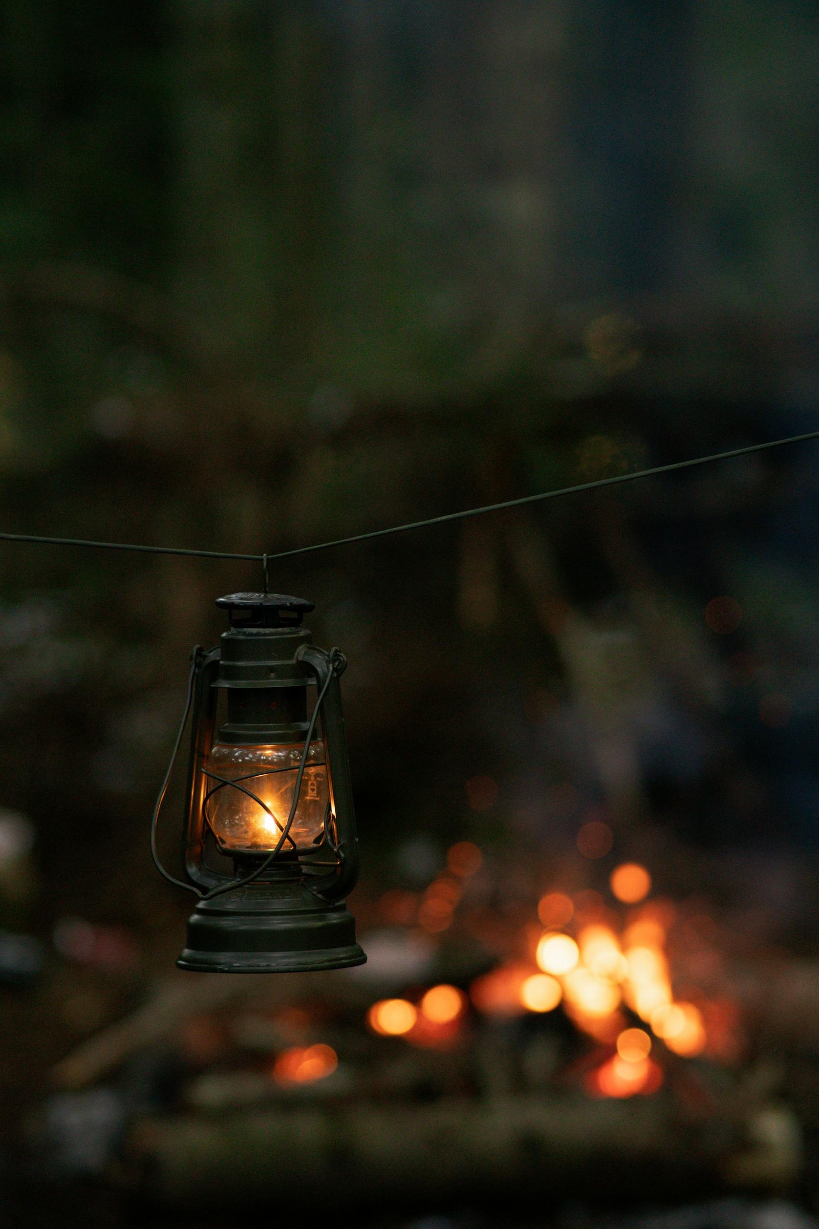 Vintage lantern hanging near a campfire